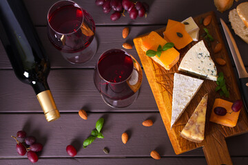 Glasses and bottle of red wine with cheese and nuts. View from above, top view
