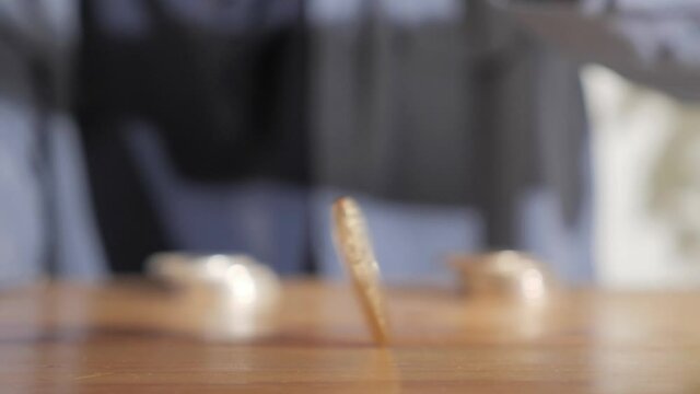 A person rolling bitcoin coin cryptocurrency on table, digital asset investment