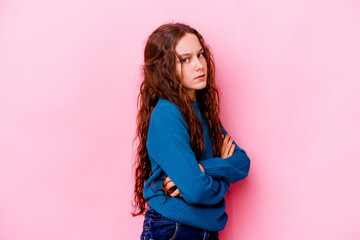 Little caucasian girl isolated on pink background frowning face in displeasure, keeps arms folded.