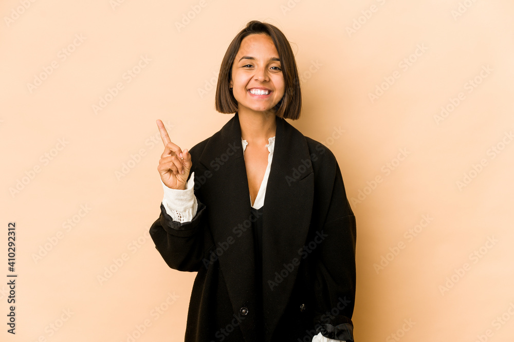 Wall mural young hispanic woman isolated showing number one with finger.