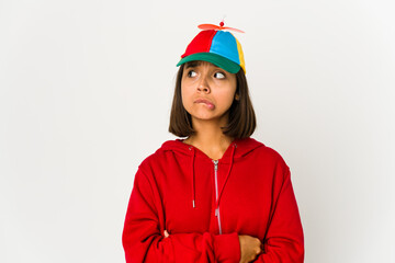 Young hispanic woman wearing a cap with propeller isolated confused, feels doubtful and unsure.