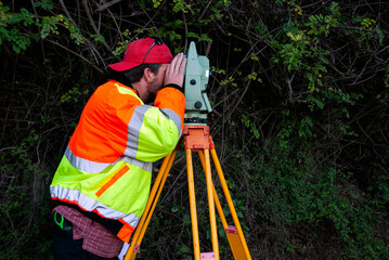 Surveyor using a theodolite