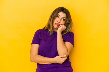 Young indian woman isolated on yellow background who feels sad and pensive, looking at copy space.