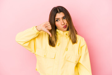 Young indian woman isolated on pink background showing thumb down, disappointment concept.