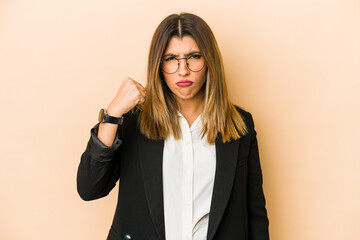 Young indian business woman isolated showing fist to camera, aggressive facial expression.