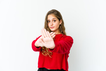 Young caucasian woman standing with outstretched hand showing stop sign, preventing you.