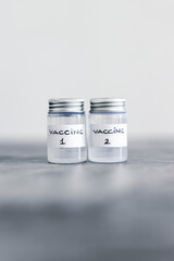 covid-19 vaccine race and immunisation against the pandemic, ampoules with Vaccine 1 and Vaccine 2 labels side by side