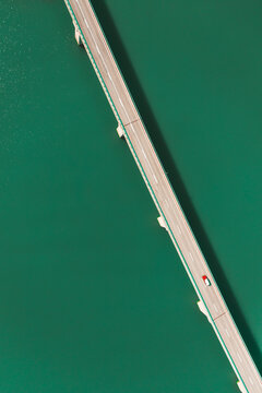 Aerial view of a car driving on the bridge crossing Pant&agrave; de la Baells lake near Cercs, Catalonia, Spain.