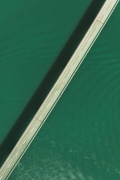 Aerial view of a car driving on the bridge crossing Pant&agrave; de la Baells lake near Cercs, Catalonia, Spain.