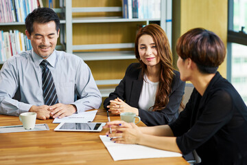 three asian businesspeople meeting discussing business in office