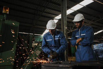 Young manual worker using grinder on metal in factory. Worker grinding in a workshop. Heavy...