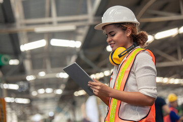 Engineer Female in using Tablet in Foundry worker in factory on the machine. portrait of an...