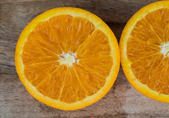 close up from top view of a slice fresh juicy orange on wooden table. Delicious fruits which have a lot of good qualification for preventing sickness and nourishment