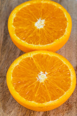 close up from top view of a slice fresh juicy orange on wooden table. Delicious fruits which have a lot of good qualification for preventing sickness and nourishment