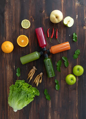 Bottle of fruit and herbal juice from cold pressed with fruits spice and vegetable placing around...