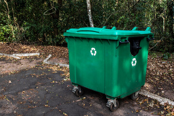 Large green recycle bin on the street of a park in Brazil