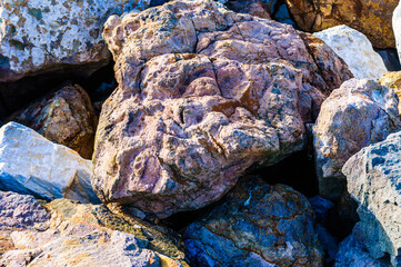 close up detail of rock surface with variety of colors under natural sunlight