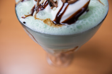 Milkshake with chocolate chips and syrup on a table
