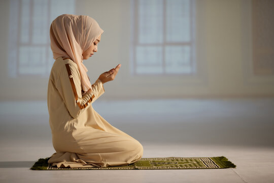 Beautiful Muslim Woman In Hijab Dress Sitting In Mosque And Praying