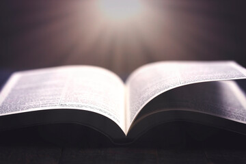 A Bible Open on a Rustic Wooden Table with Pages Blowing Open