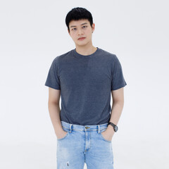 portrait of a handsome young Asian man with short black hair wearing a black T-shirt and blue jean pants looking at a camera studio shot isolated over white background.