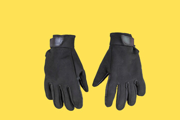 sport black gloves for mountaineering and gym on yellow isolated background