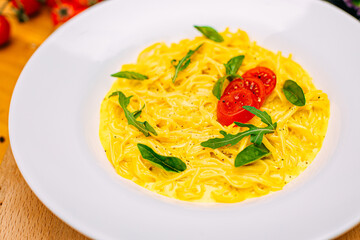 spaghetti with cheese and tomatoes on a decorated table