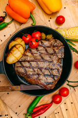 t-bone steak with grilled vegetables on a decorated table