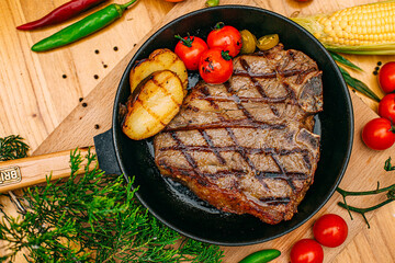 t-bone steak with grilled vegetables on a decorated table