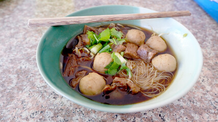 Beef ball noodle on the marble table in the restaurant.