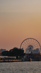 Landscape view of Farris Wheel at Chao Praya river in sunset, Bangkok, Thailand
