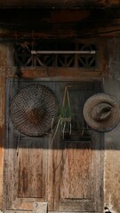 Traditional Chinese hat made of bamboo hanging on wooden window, retro decoration background