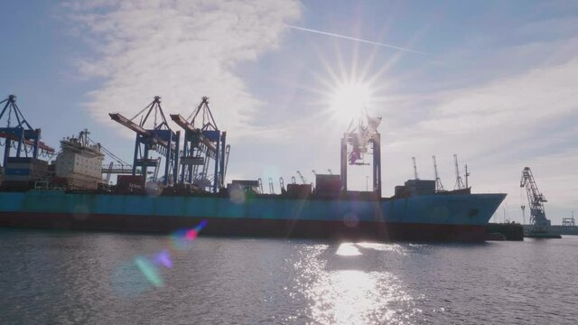 a massive container ship in Hamburg with the Container Gantry Cranes on a sunny day in Hamburg, Germany