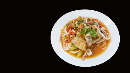 seafood spicy salads in white plate on black background. 