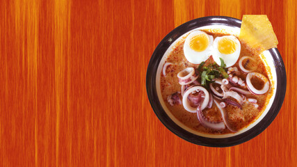 squid in spicy soup on colorful background. spicy soup with squid on wooden table.tom yum squid
