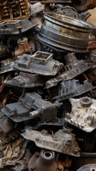 Pile of old machine parts in second hand machinery shop, background of damage and rusty old car machine