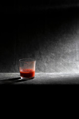 Glass cup with tomato juice on a dark background