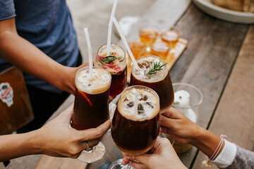Group of friends enjoying coffe cocktail in wine glass. Creative new exotic cocktail drinks a combination of cold brew coffee with juice. 
