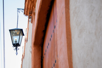 Classic lantern hanging from old building under a blue sky