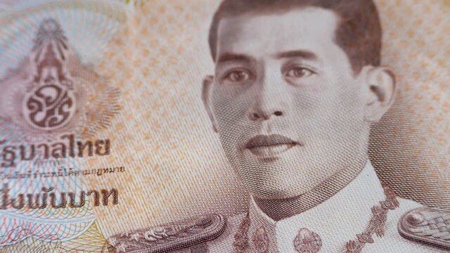 Face King Maha Vajiralongkorn and monogram on 1000 baht banknote. Tenth monarch of Thailand from Chakri dynasty, titled Rama X. Uniform of commander of Royal Thai Air Force