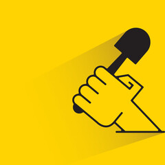 hand holding cleaning brush with shadow on yellow background