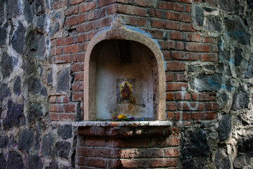 Fototapeta na wymiar Small altar on the corner of a stone wall