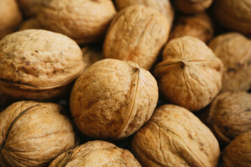 Walnut background. Natural walnuts texture. Nuts in shells. Stacked pile of wallnuts pattern.
