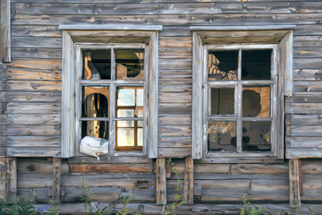 Obraz na płótnie Canvas Old destroyed abandoned raw wooden house with the broken out windows