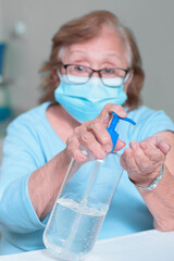 closeup on the hands of an elderly woman placing antibacterial gel as a method of prevention in pandemic