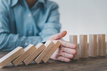 close-up hand The hand of a businessman who is stopping or preventing a falling block.Risk...
