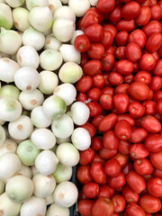 Grupo de cebollas y tomates, verduras  presentadas a consumidores en un mercado