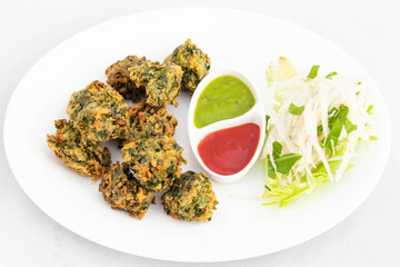 Indian Fritters Chaat Snacks Palak Pakoda Bhajji Chat Or Paalak Pakora Bajji Bhajiya Made Of Chopped Spinach Dhaniya Pudina Leaves And Gram Dal Flour Besan Masala Daal Served With Red Chutney Sauce