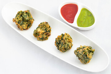 Spiced Indian Chaat Snacks Palak Pakoda Bhajji Chat Or Paalak Pakora Bajji Bhajiya Made Of Chopped Spinach Dhaniya Pudina Leaves And Gram Dal Flour Besan Masala Daal Served With Red Chutney Sauce