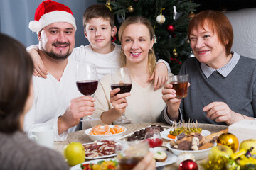 Portrait of large friendly family during celebration of New Year at table at home